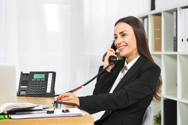 young-businesswoman-smiling-while-talking-telephone-office_23-2147943661.jpg